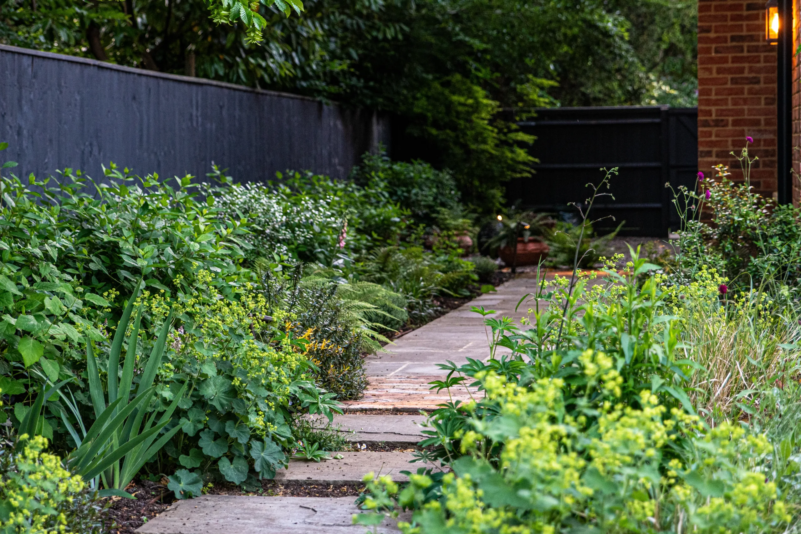 Children exploring woodland garden with natural play features