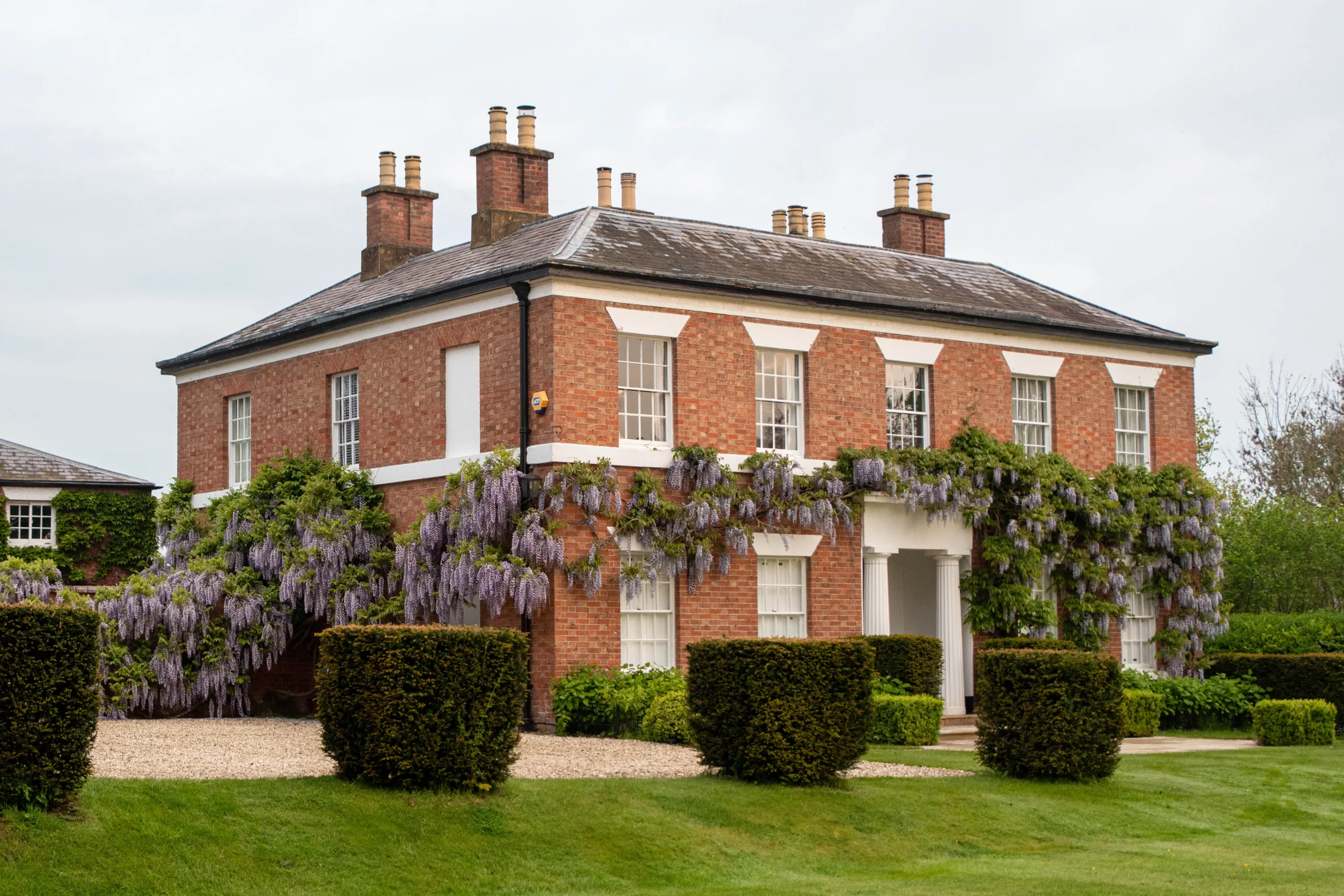 Warwickshire country house garden with wisteria climbing Georgian façade