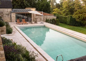 Oxfordshire garden design with pool and rill featuring natural stone paving