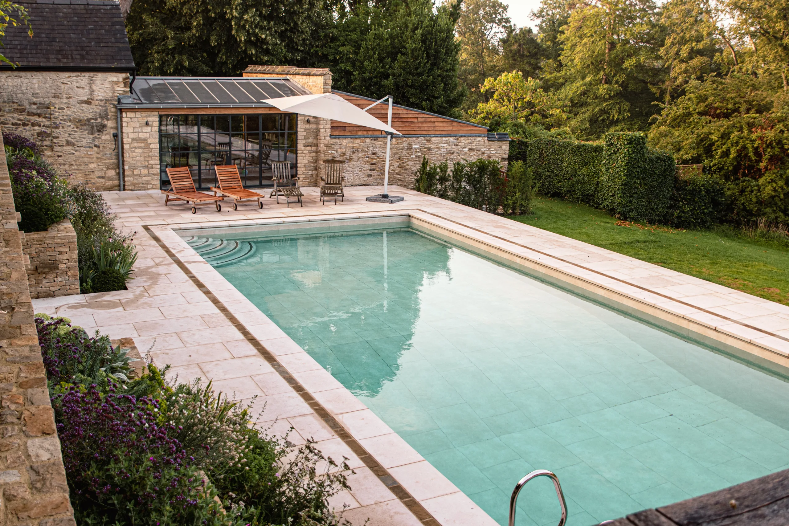 Oxfordshire garden design with pool and rill featuring natural stone paving