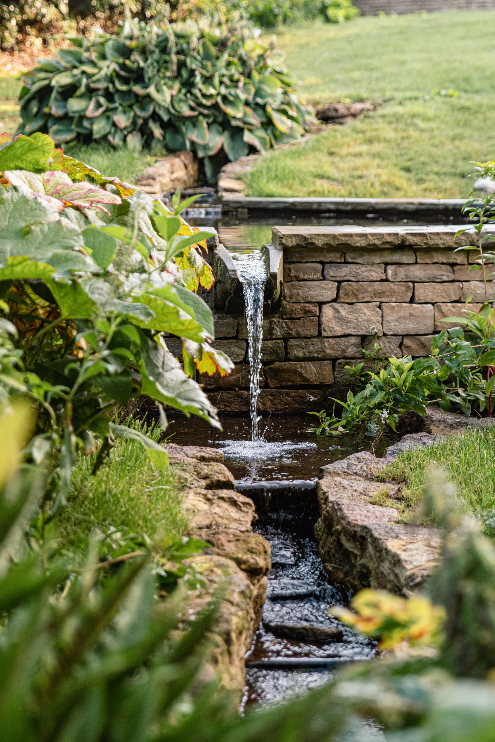 Evening view of Oxfordshire garden design with pool and rill lighting